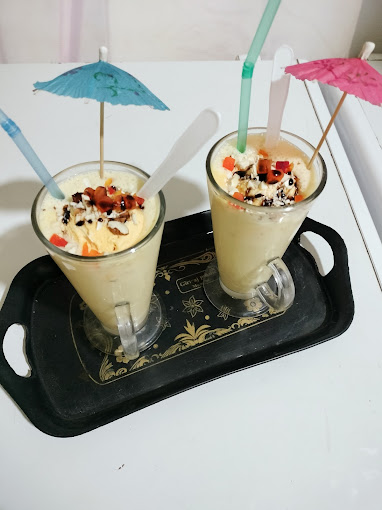 Overhead shot of two mastani flavors—mango, sitaphal, and anjeer—lined up on a counter
