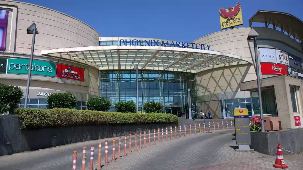 Phoenix Market City Pune mall with shoppers and store entrances.”
