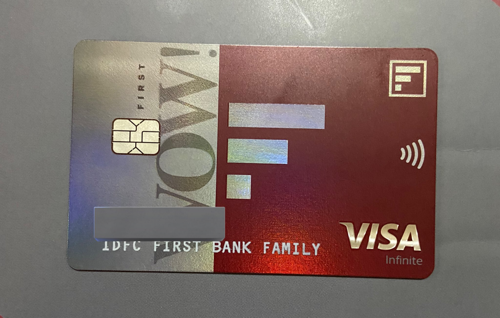 IDFC FIRST WOW student credit card in vibrant blue with the word ‘WOW’ in large, white letters across its face, set against a clean white backdrop