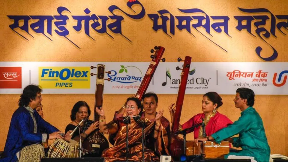 Live performance at Sawai Gandharva Sangeet Mahotsav in Pune, featuring renowned Hindustani classical musicians on stage under festive lighting with a captivated audience.