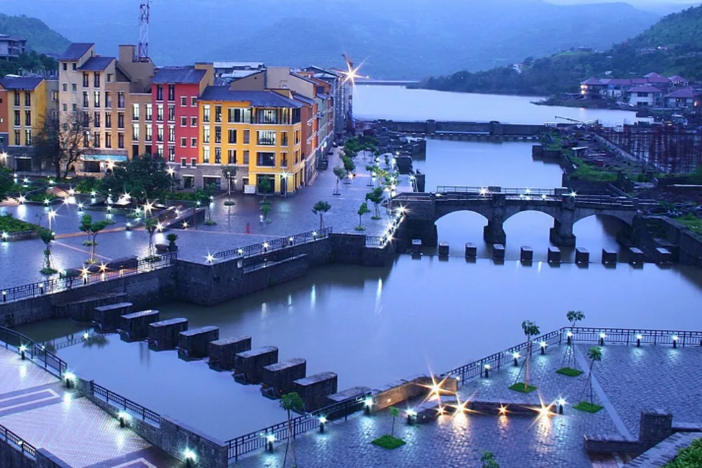 Lavasa promenade lit up at night with lake reflections