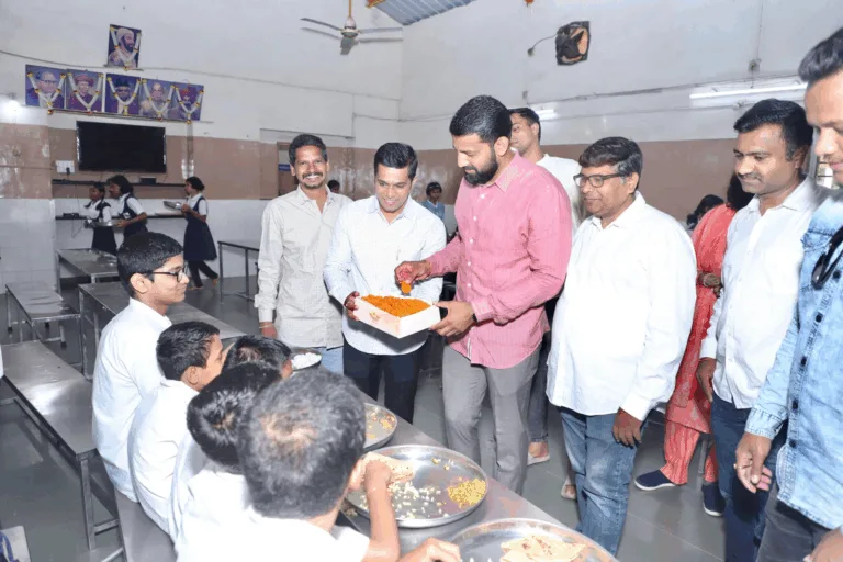 Community volunteers distributing food and books in Wanawadi during birthday celebration