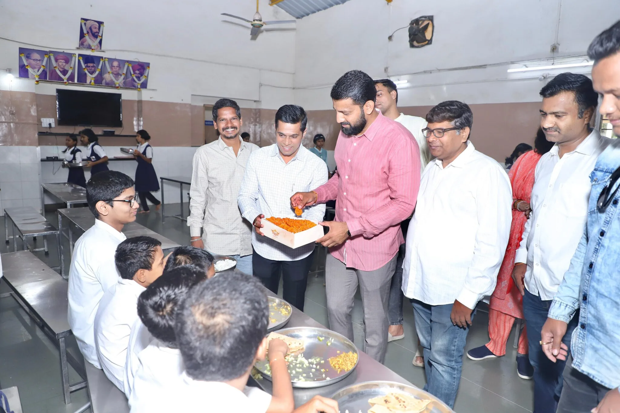 Community volunteers distributing food and books in Wanawadi during birthday celebration