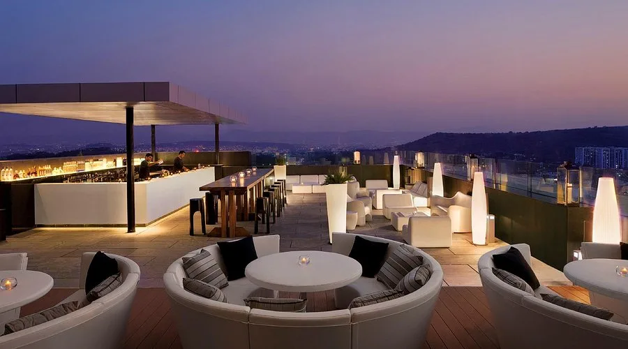 Pune city skyline at night, tables set on a rooftop